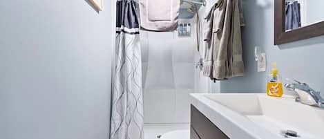 Un baño con ducha, inodoro y lavamanos.