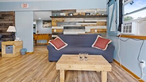 Un interior moderno con un sofá, una mesa de centro de madera y una pared revestida de tablones.