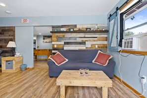 A modern interior with a sofa, wooden coffee table, and a wall with wooden planks.