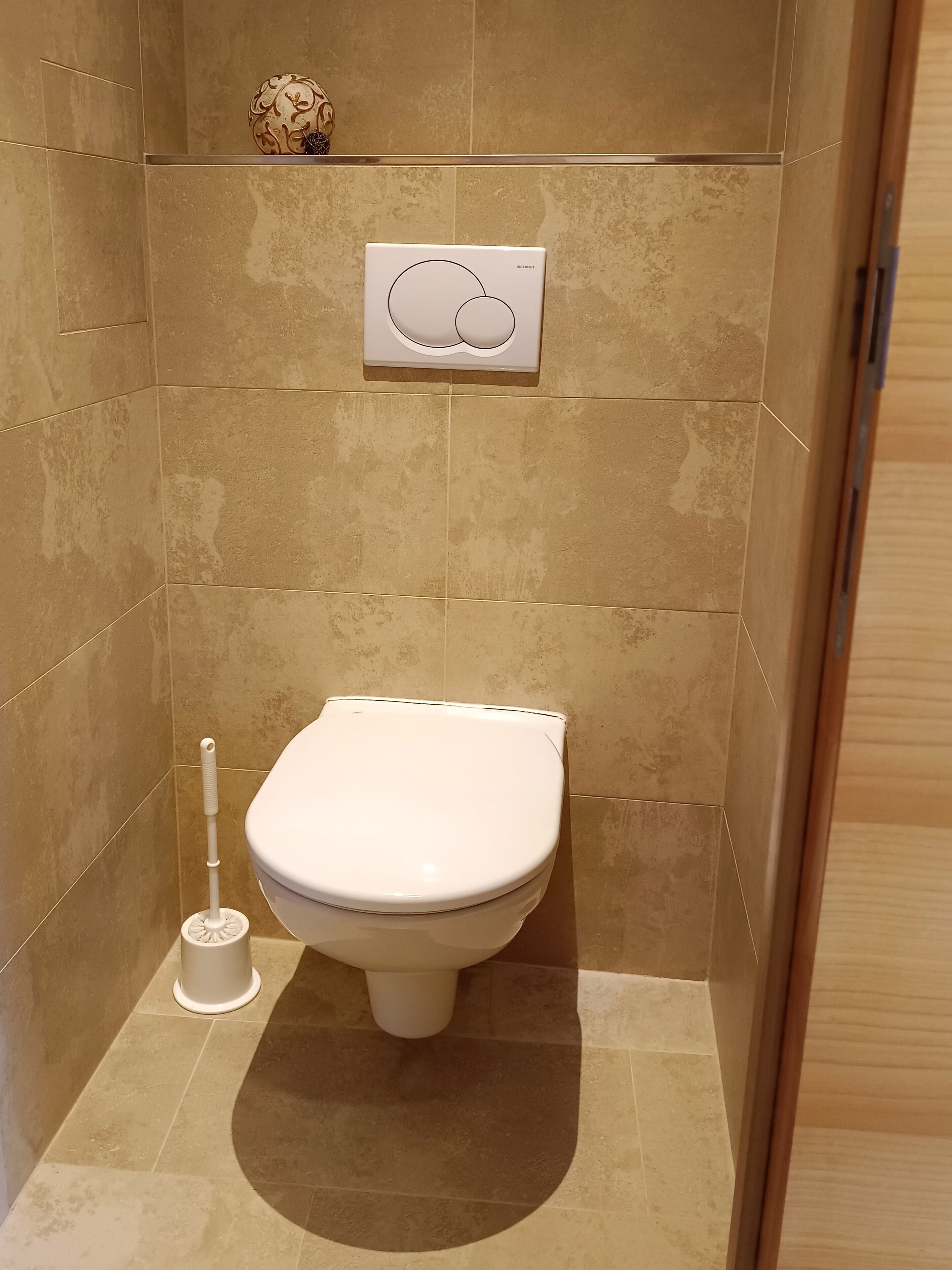 Une salle de bain équipée de toilettes, d’un bidet et d’un système de chasse d’eau mural.