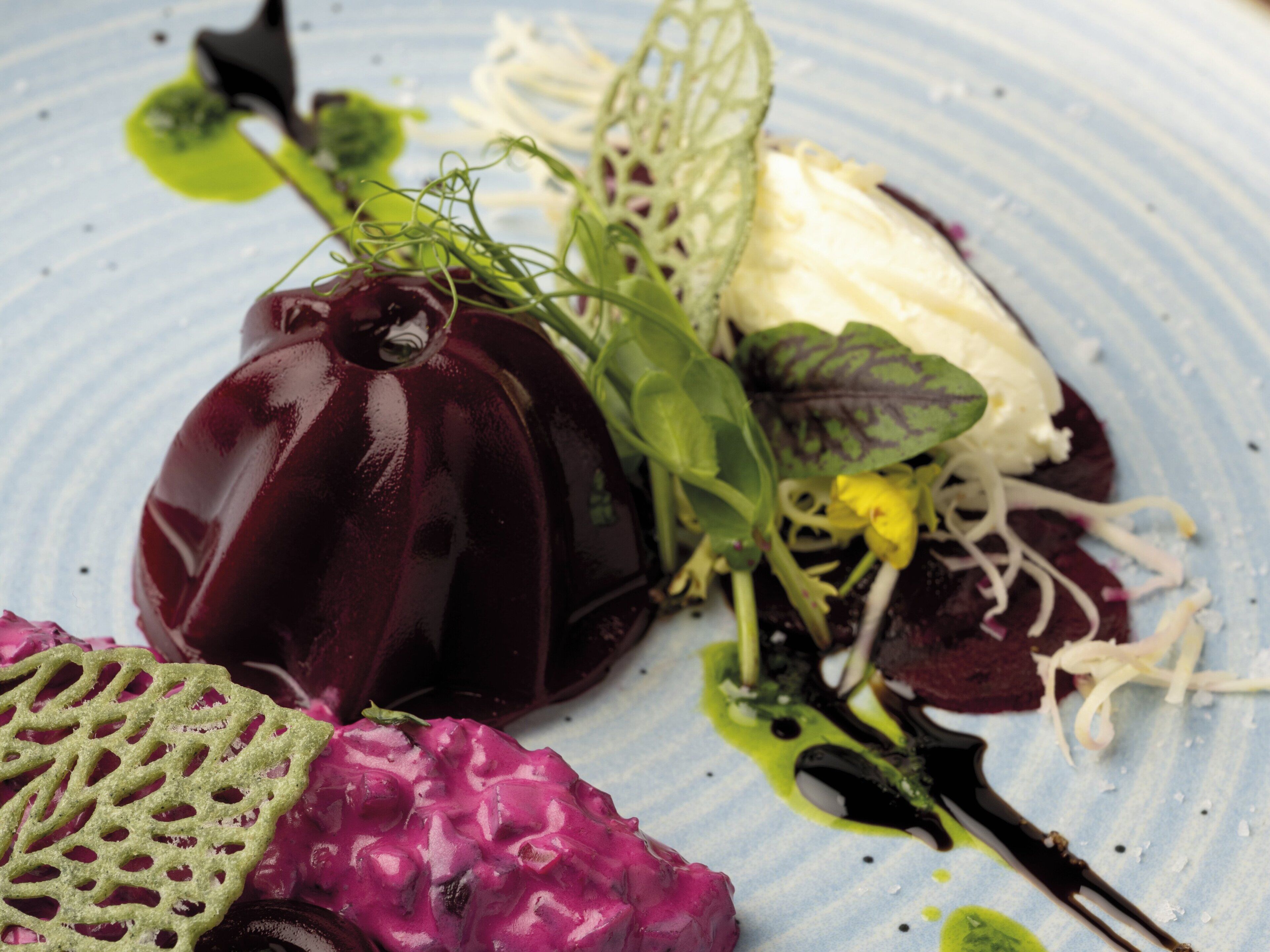 A dish with various vegetables and a piece of meat on a plate.