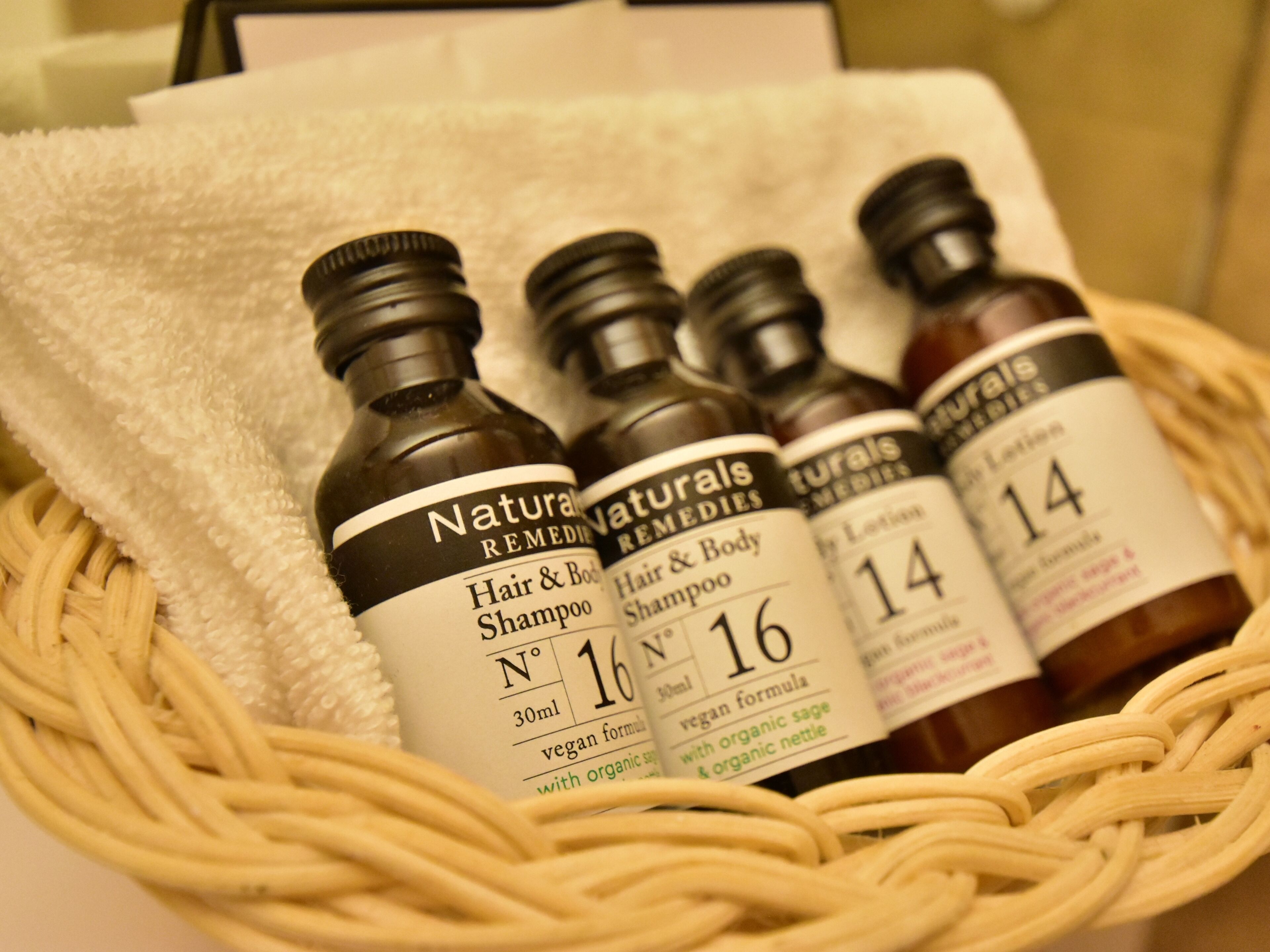A basket containing bottles of hair and body shampoo labeled with different numbers and ingredients.
