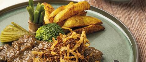 Un plato de comida con carne, papas fritas y verduras.