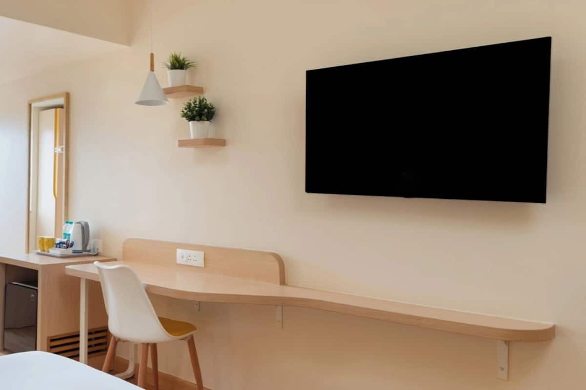 Ett modernt rum med ett skrivbord, en stol och en väggmonterad TV.