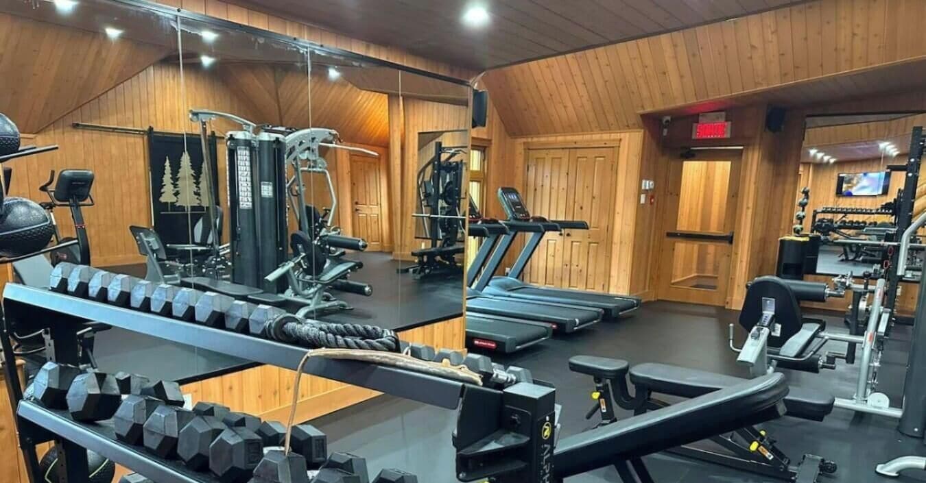 A gym with various exercise equipment including treadmills, weight machines, and dumbbells.