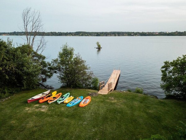 A grassy area with a wooden dock extending into a calm lake, surrounded by trees. - Hollywood / Private Beach / SPA / Games / 16 P (Brownsburg-Chatham)