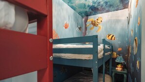 Een kinderbed met een stapelbed en een muurschildering van zeedieren.