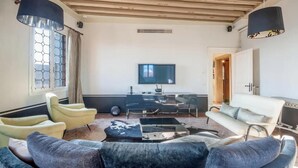 A living room with a TV, sofa, chairs, and a desk with a computer. - LUXURY GOTHIC PALAZZO - 340 SQM WITH TERRACE A.C, STEPS FROM ARSENALE & BIENNALE (Venice)