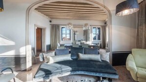 A modern living room with a large sectional sofa, a dining area, and a kitchen in the background. - LUXURY GOTHIC PALAZZO - 340 SQM WITH TERRACE A.C, STEPS FROM ARSENALE & BIENNALE (Venice)