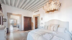 A spacious bedroom with a large bed, wooden wardrobe, and a chandelier. - LUXURY GOTHIC PALAZZO - 340 SQM WITH TERRACE A.C, STEPS FROM ARSENALE & BIENNALE (Venice)