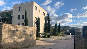 A modern building with a stone wall labeled "Domaine du Frasso" and a sign indicating "Let It" and "Café".