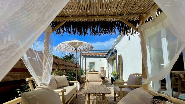 An outdoor seating area with wooden furniture and a canopy.
