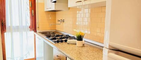 Kylskåp, mikrovågsugn, spishäll och grytor/köksredskap