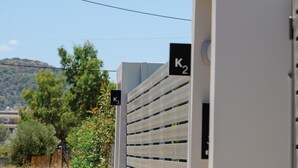 A modern building with a white facade and a slatted design on the side. There are signs indicating 'K2' and 'K3' on the building. - Komos Villas by Airstay (Spata-Artemida)