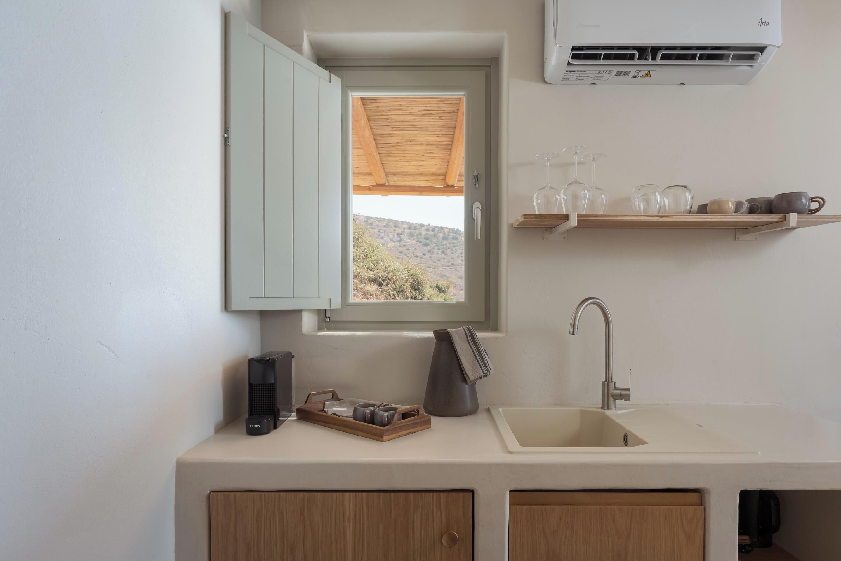 Una cucina moderna con una finestra, un lavello e un armadietto in legno.