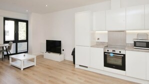 A modern kitchen with white cabinets, a built-in oven, and a microwave. - Modern Comfort: Seven Stays Broadoaks (Solihull)