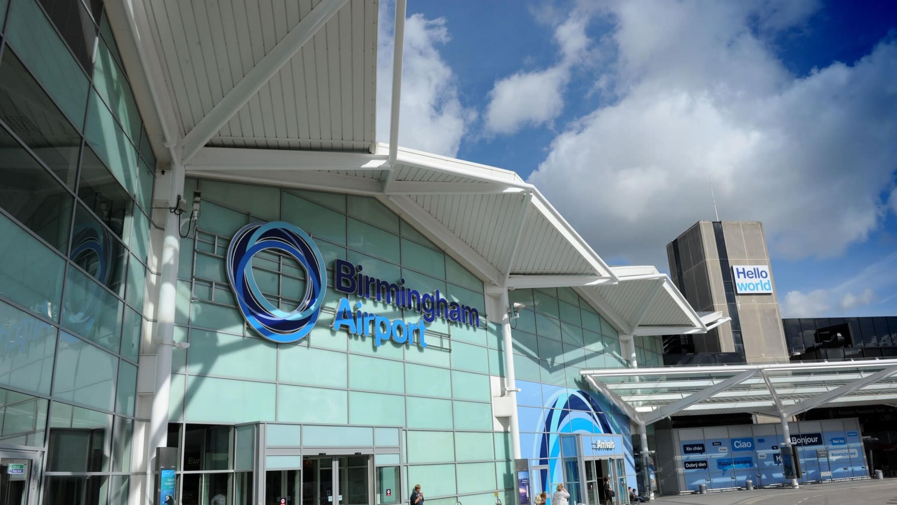 Birmingham Airport with a modern glass facade and a prominent blue logo.