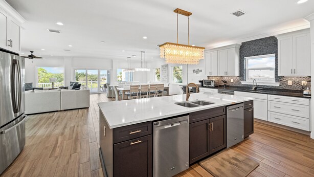 A modern kitchen with a large island, stainless steel appliances, and a view to the outside. - Papa’s Beach House | 11BR/11.5BA Gulf Shores | Private Pool Coastal Escape (Gulf Shores)