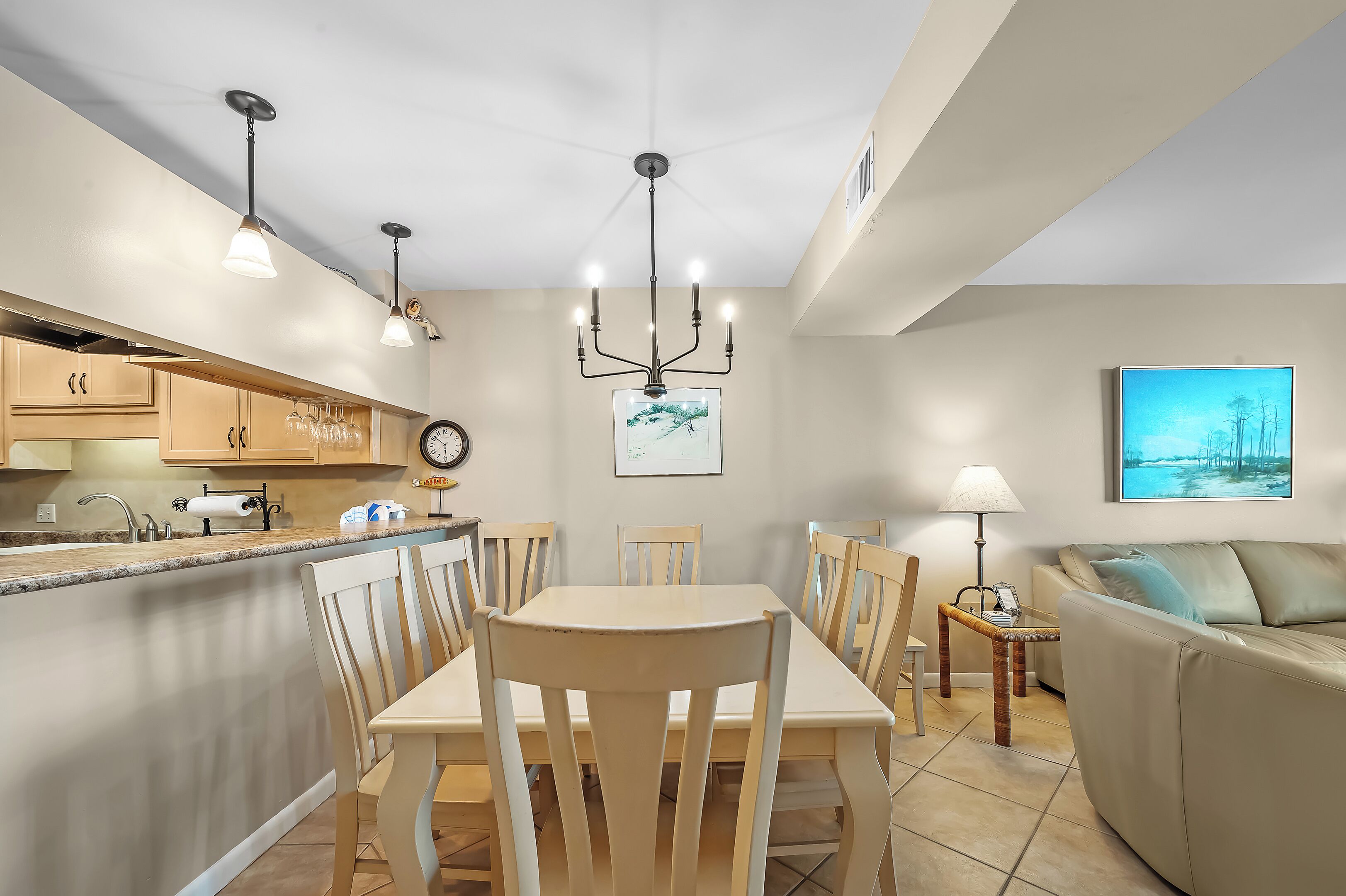 Une cuisine moderne avec un coin repas, un canapé et un tableau au mur.