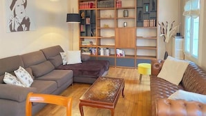 Una sala de estar con sofá, mesa de centro y estantería.