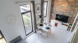 Un espace de vie moderne comprenant un coin repas, un canapé et un téléviseur.