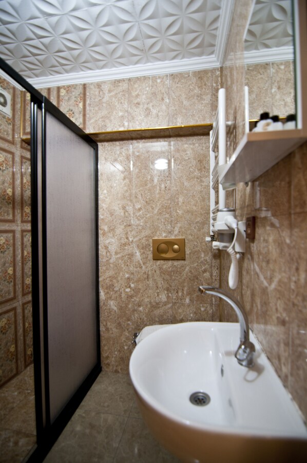 Un baño con lavamanos, espejo y toallero.