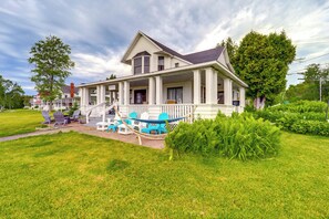 A large, two-story house with a porch, a hammock, and outdoor seating. - Waterfront Alanson Cottage w/ Dock & Lake Access! (Alanson)