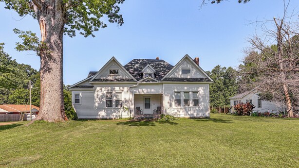 A two-story house with a front porch, a large tree in the yard, and a well-maintained lawn. - Jackson Family Home ~ 5 Mi to Downtown! (Jackson)