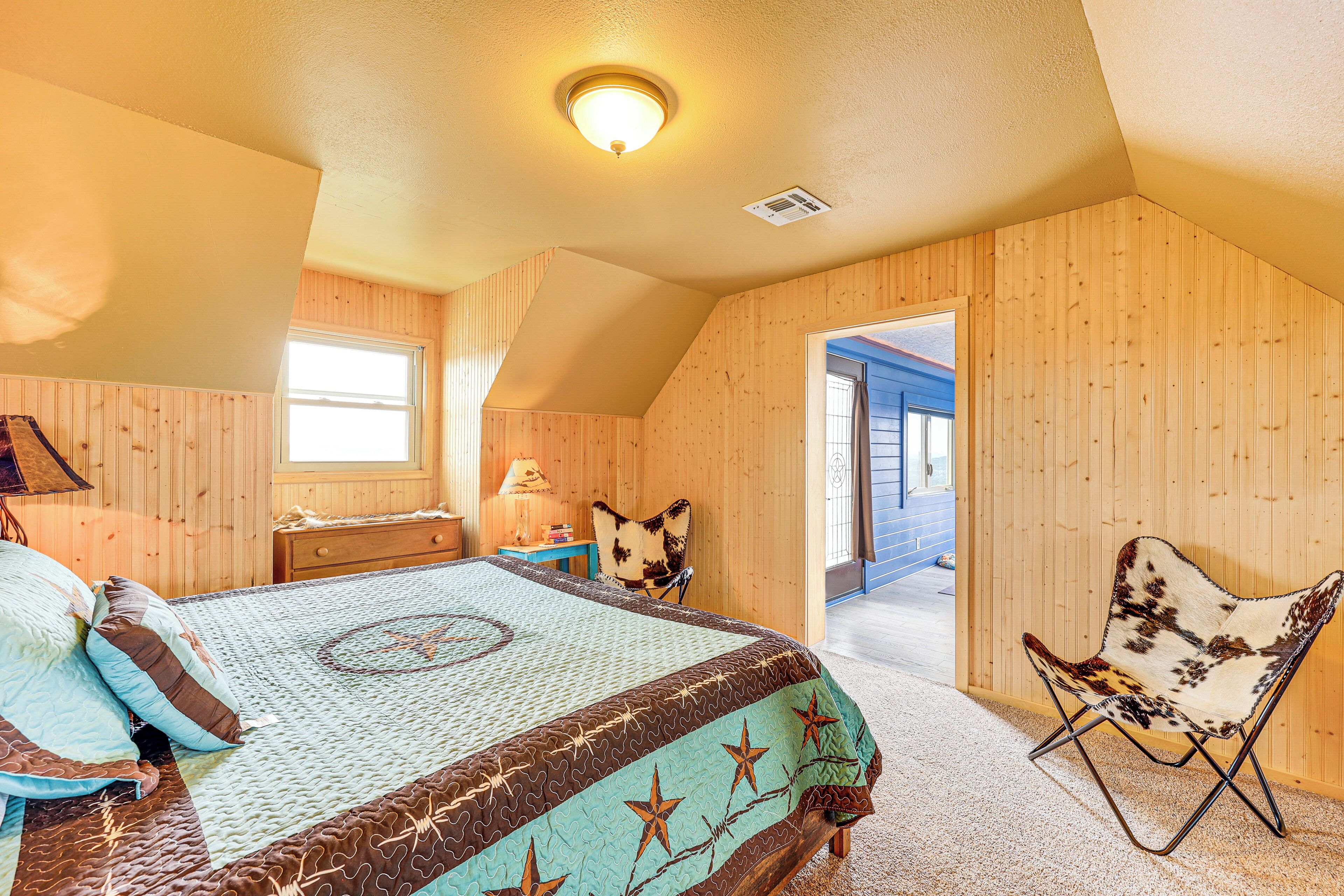 Une chambre à coucher avec un lit, une chaise, une fenêtre et des murs en bois.