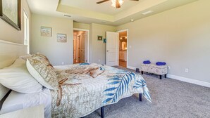 Une chambre à coucher avec un lit, un ventilateur de plafond et un sol recouvert de moquette.