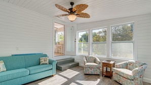 A room with a teal sofa, floral armchairs, a wooden side table, and a ceiling fan. - Chic Port Charlotte Home ~ 9 Mi to Englewood Beach (Port Charlotte)