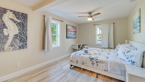 A bedroom with a bed, a ceiling fan, and artwork on the walls. - Chic Port Charlotte Home ~ 9 Mi to Englewood Beach (Port Charlotte)