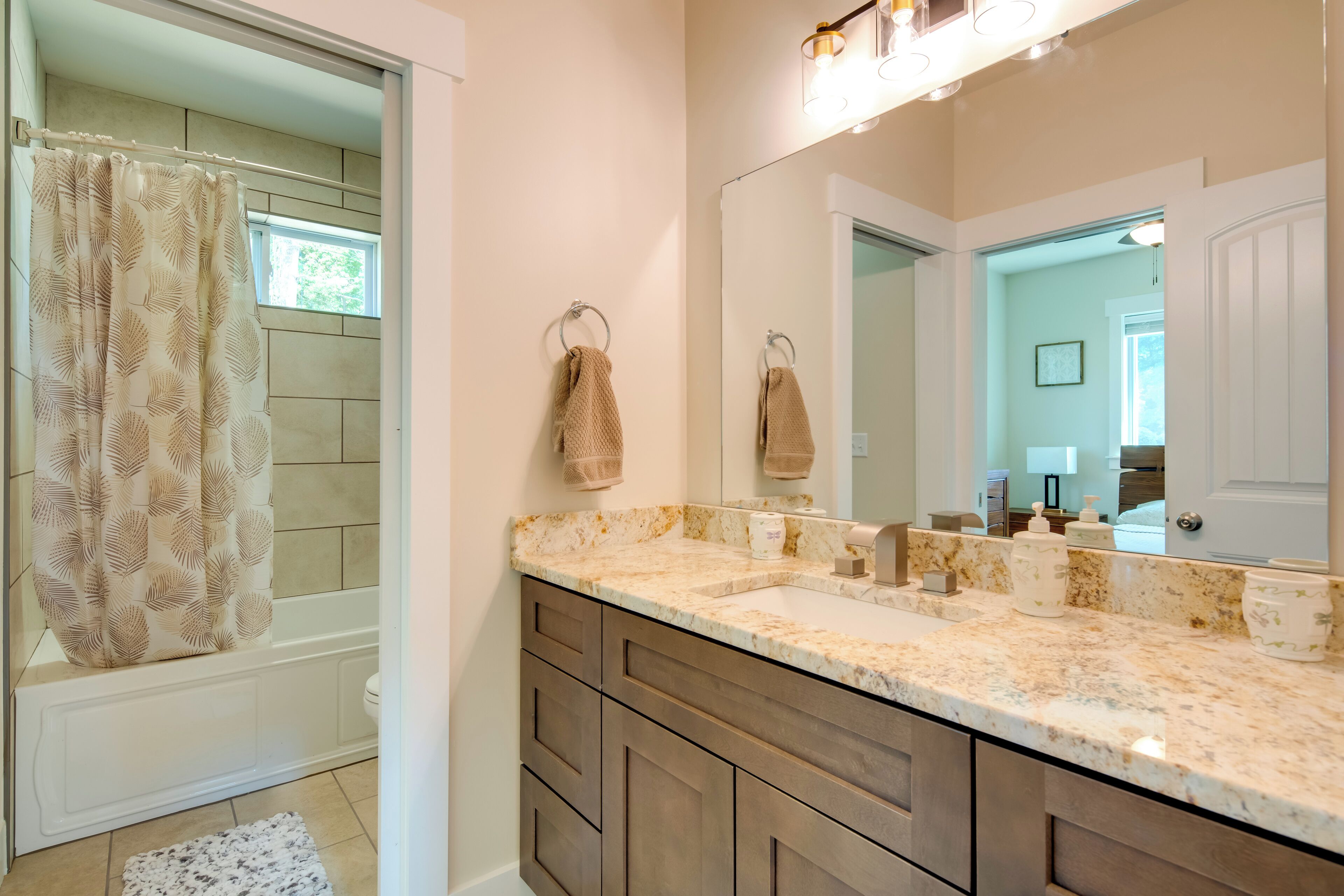 A bathroom with a double sink, a large mirror, and a shower area.