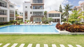 Un hôtel moderne doté d’une piscine, de nombreux balcons et d’un aménagement paysager luxuriant.