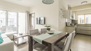 A modern apartment with a dining area, kitchen, and a balcony with a view. - Paseo Del Mar B3ALO_200Mbps_Pool_Walk to Beach & Dining! (Bavaro-Punta Cana)