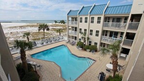 Un hôtel doté d'une piscine, offrant une vue sur la plage et comprenant plusieurs balcons.