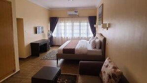 Een woonkamer met een bank, een salontafel, een televisie en een bed.