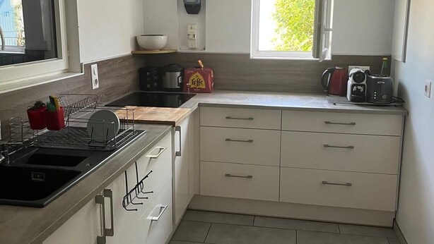 Una cucina compatta con lavello, fornelli e una finestra che fa entrare luce naturale.