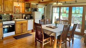 A wooden kitchen with a dining table and chairs, a refrigerator, and a stove. - Best Views-Next to RMNP-Hike from House-HotTub-Fireplace-Coaster Passes-King Bed (Estes Park)
