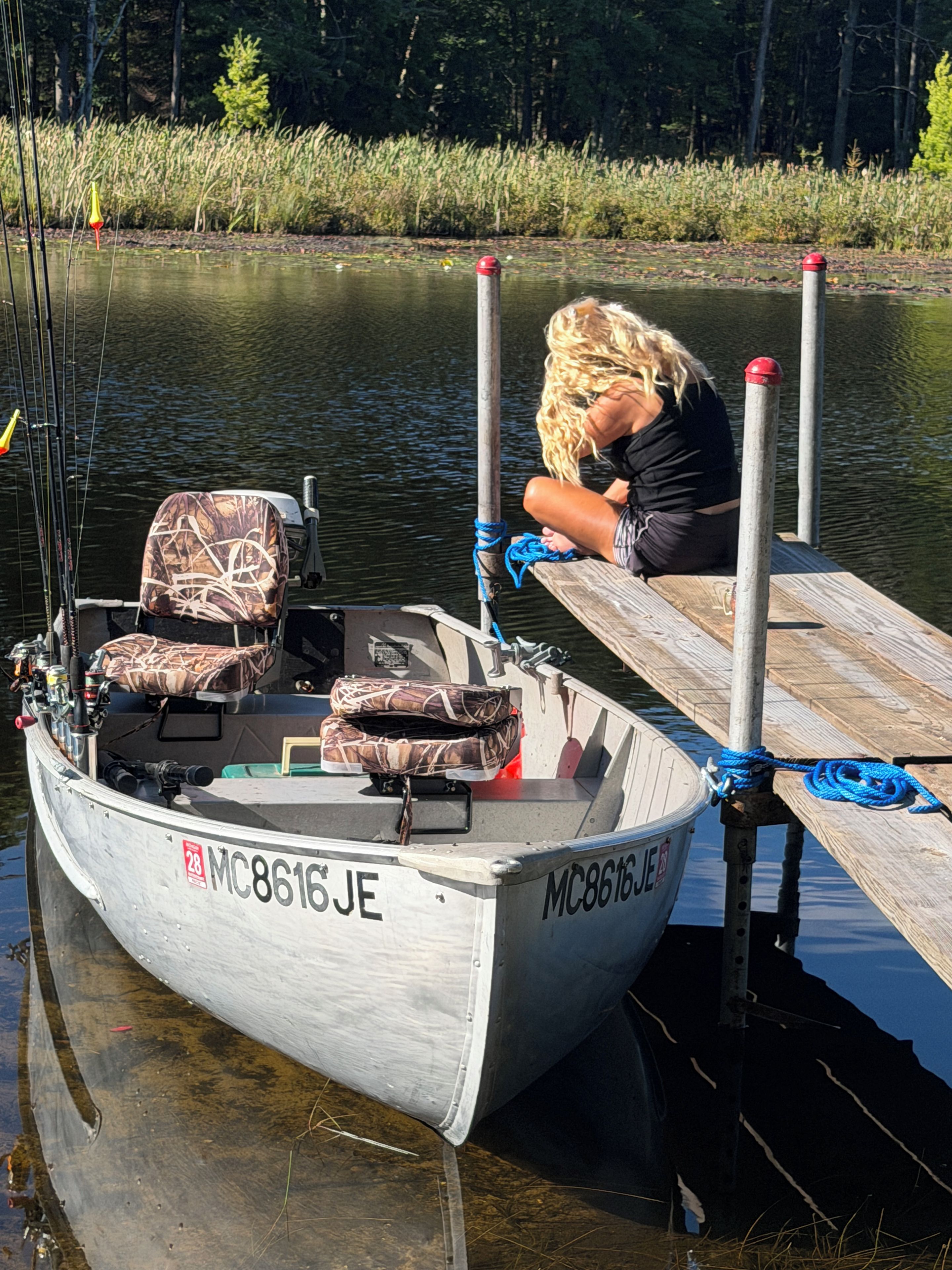 Un bateau était amarré à un quai, et une personne était assise au bord.