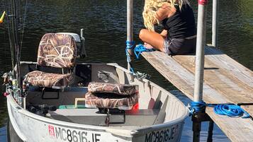 Un bateau était amarré à un quai, et une personne était assise au bord.
