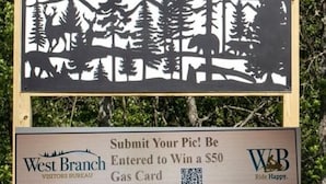 Un panneau représentant la silhouette d’un cheval et d’arbres, et un panneau plus petit indiquant l’emplacement d’un bureau d’information touristique, avec un code QR.