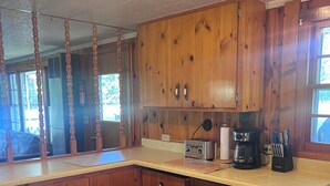 Une cuisine avec des armoires en bois, un plan de travail et un plancher en bois.