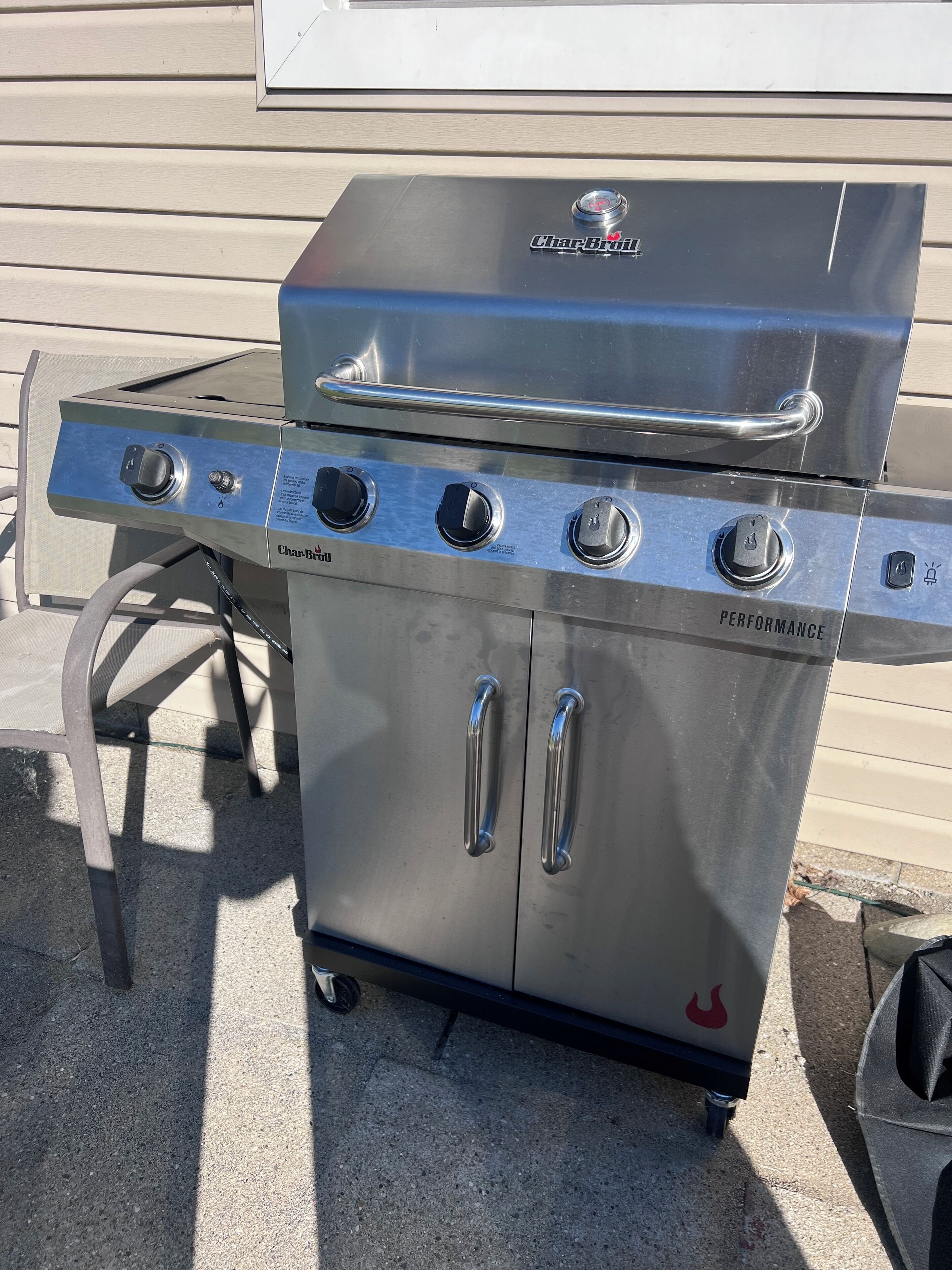 A Char-Broil gas grill with three burners, a side shelf, and a stainless steel finish.