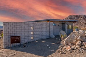 A modern building with a tiled facade and a sign indicating it is the Orion Joshua Tree.