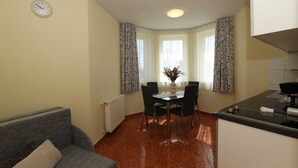 A compact living space with a dining area, a kitchenette, and a sofa.