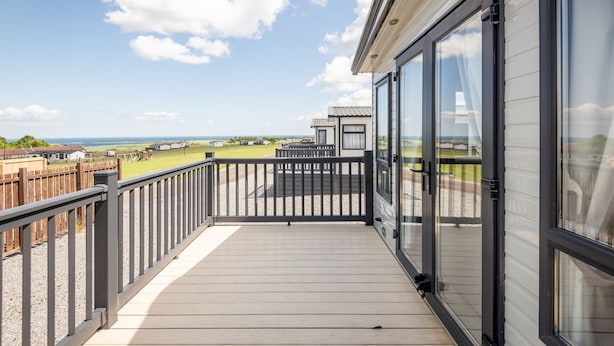 En balkon med udsigt over stranden og havet.