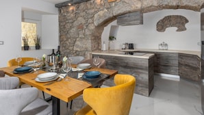 Una cucina moderna con un arco in pietra, un tavolo da pranzo in legno e sedie gialle.