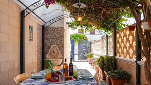 An outdoor dining area with a table set for two, surrounded by potted plants and a decorative wall. - Casa Crystal Near The Sea - 5min Walk to San Foca (Melendugno)
