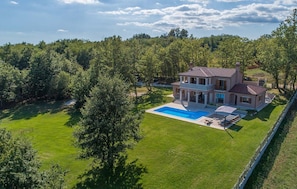 A large house with a swimming pool, surrounded by a well-maintained lawn and trees. - Villa Anima in Pazin (Pazin)